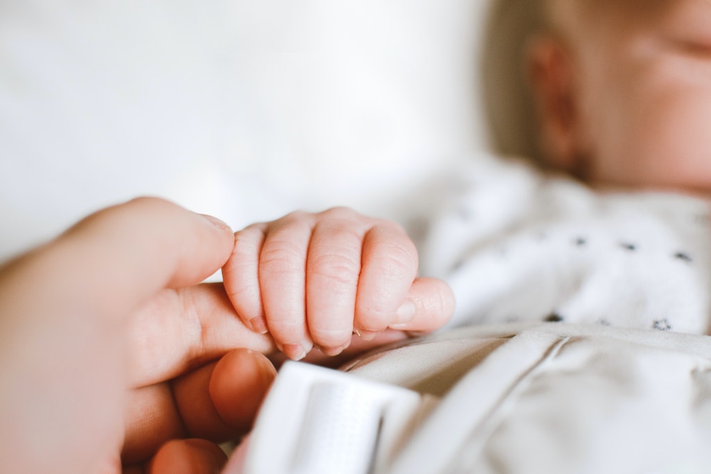 Baby hält Hand von Mutter